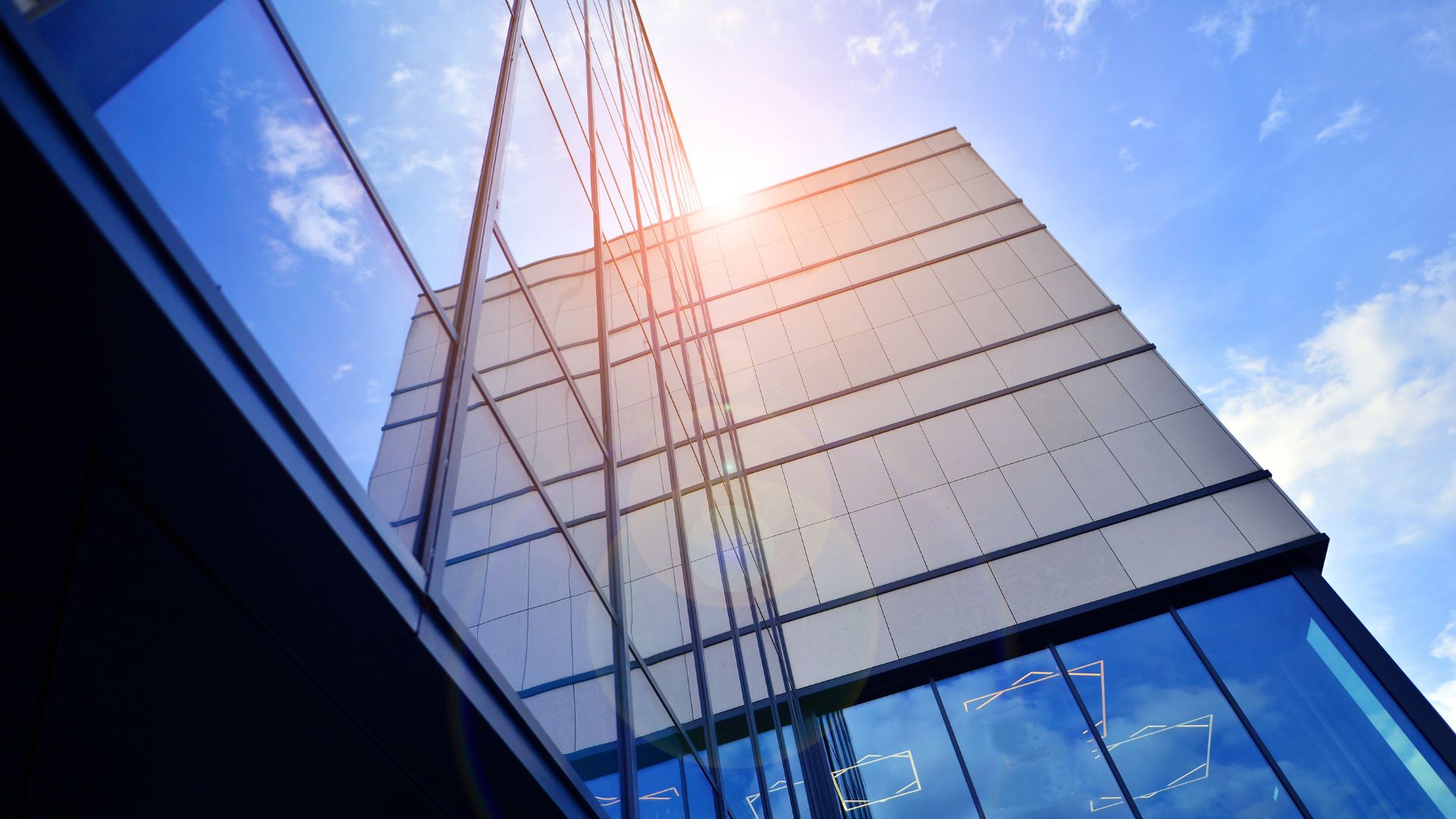 Glasfassade eines Bürogebäudes steht sinnbildlich für Cyber Security und den Schutz sensibler Unternehmensdaten im Medienbereich.