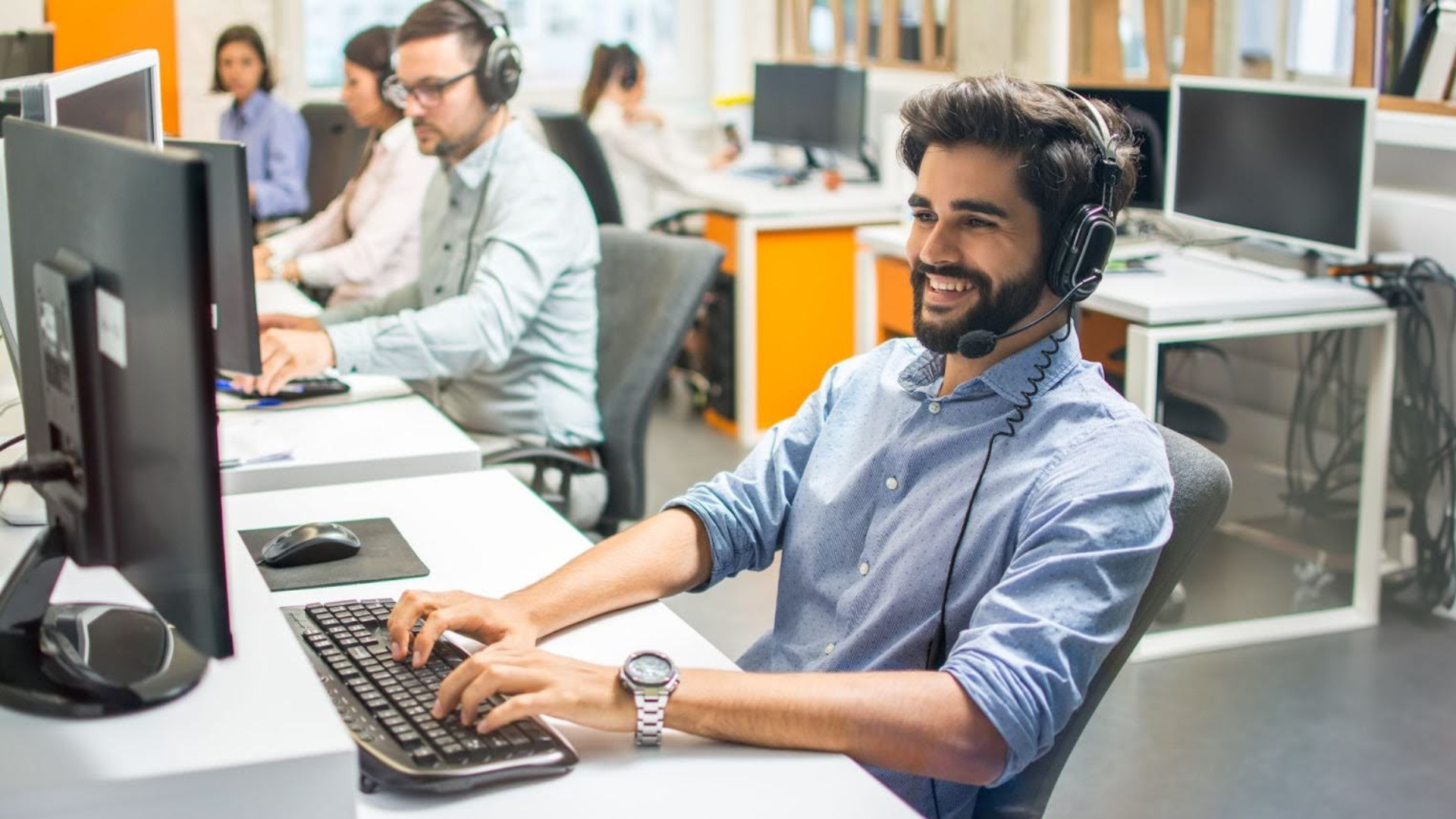 mitarbeiter-it-computer-headset-schreibt-laechelt_rs