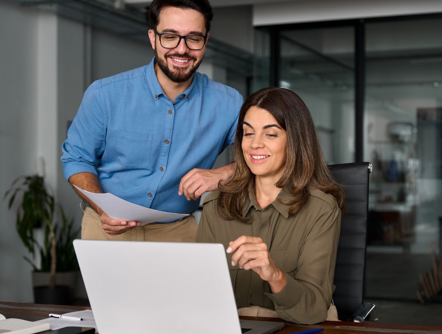 Hände mit orangefarbenen Handschuhen prüfen einen Autoreifen in der Werkstatt.