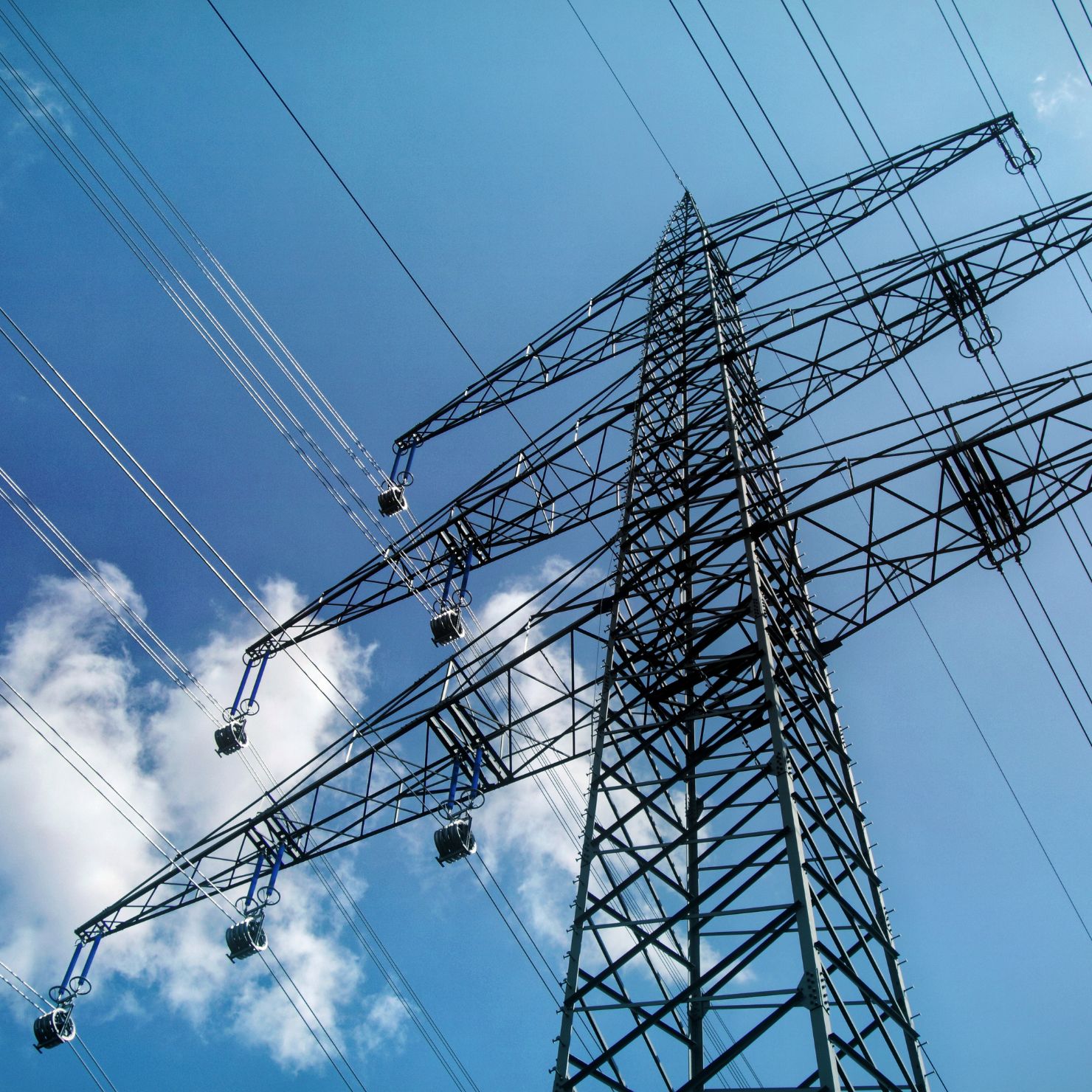 Ein Strommast vor blauem Himmel symbolisiert die kritische Infrastruktur eines norddeutschen Stadtwerks und die Bedeutung von Cybersecurity sowie Ransomware-Schutz im Ernstfall.